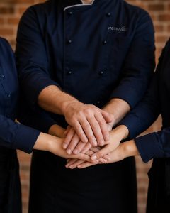 Das VASUNAflair-Team aus 3 Personen reicht sich die Hände.